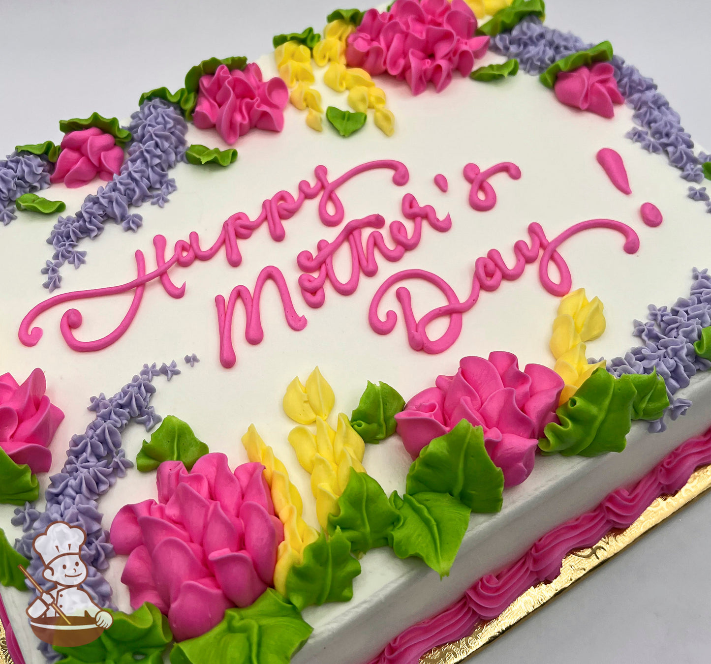 Sheet cake with buttercream decorations featuring pink bell flowers, yellow lupines, purple florals, and green leaves, vibrant and colorful design.