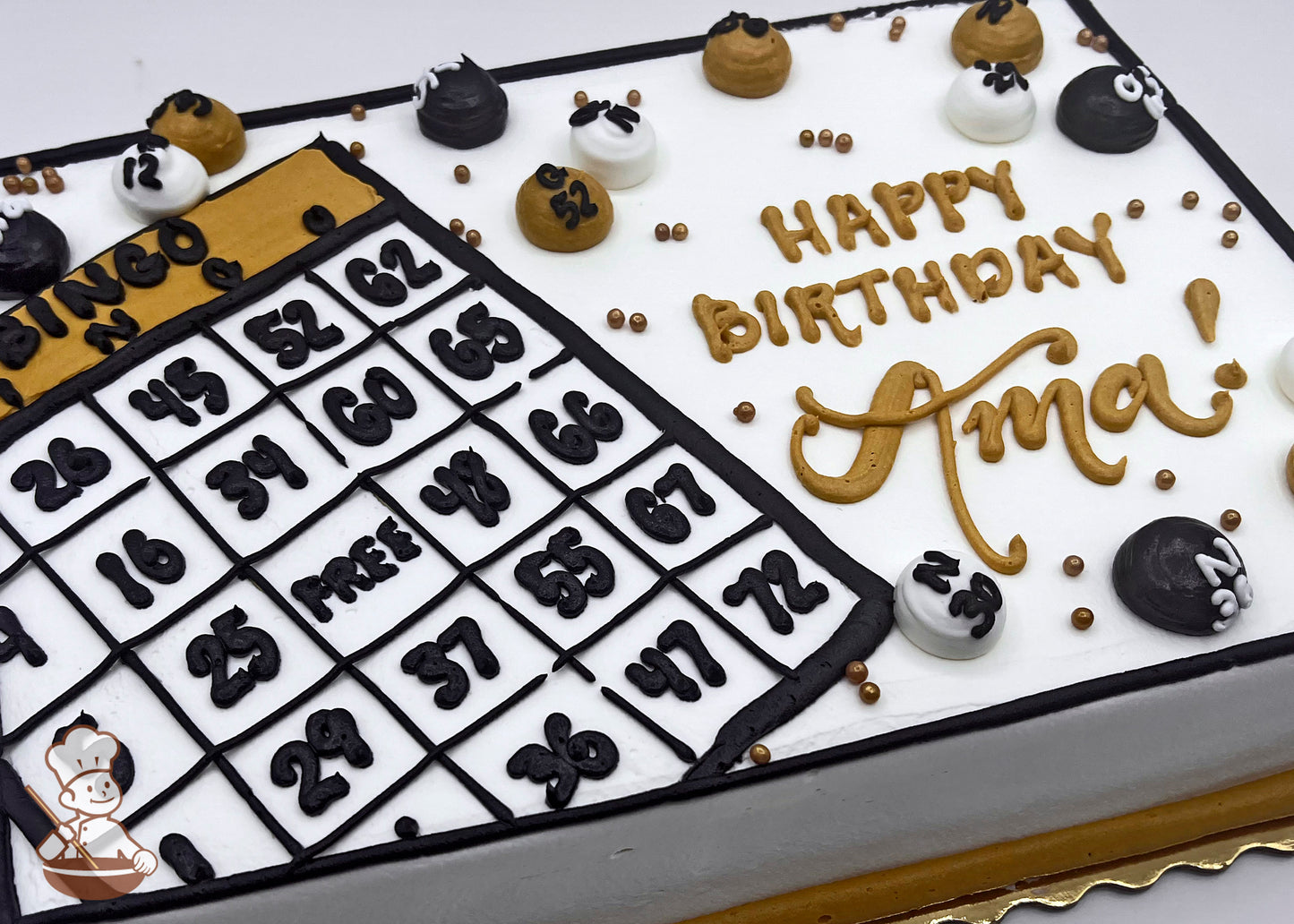 Sheet cake with buttercream bingo card and balls, decorated in black, white, and gold. Gold, black and white buttercream dots scattered around.