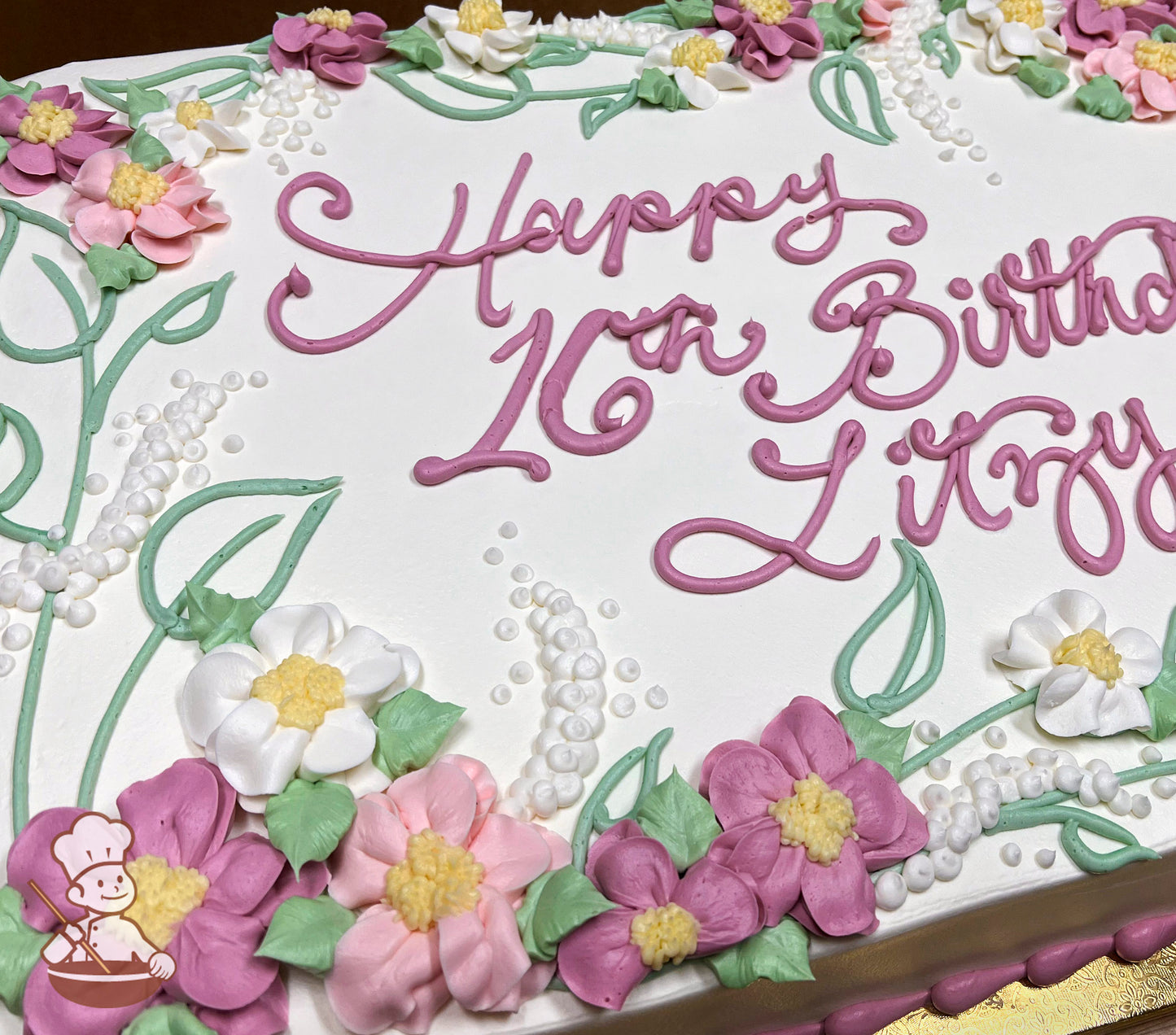 Sheet cake with buttercream flowers, including pink and white blossoms, white lupines, and green ferns.