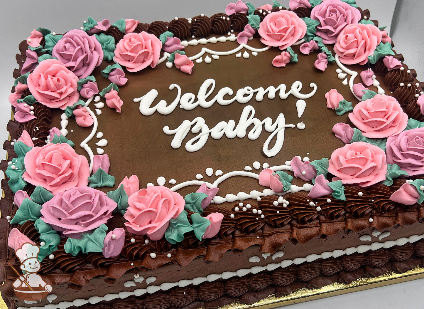 Sheet cake with buttercream decorations, pink roses, green leaves, white piped accents, and rose border design.