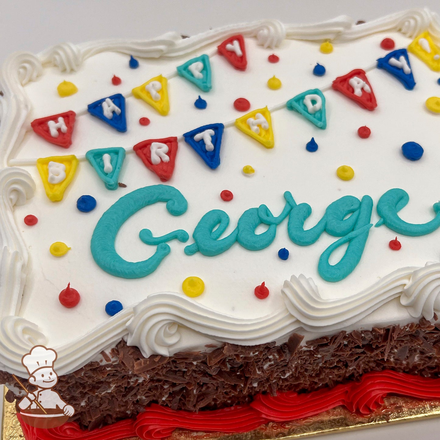 Sheet cake with white frosting, colorful "Happy Birthday" banner decorations, red, yellow, and blue dots, and red frosting trim.