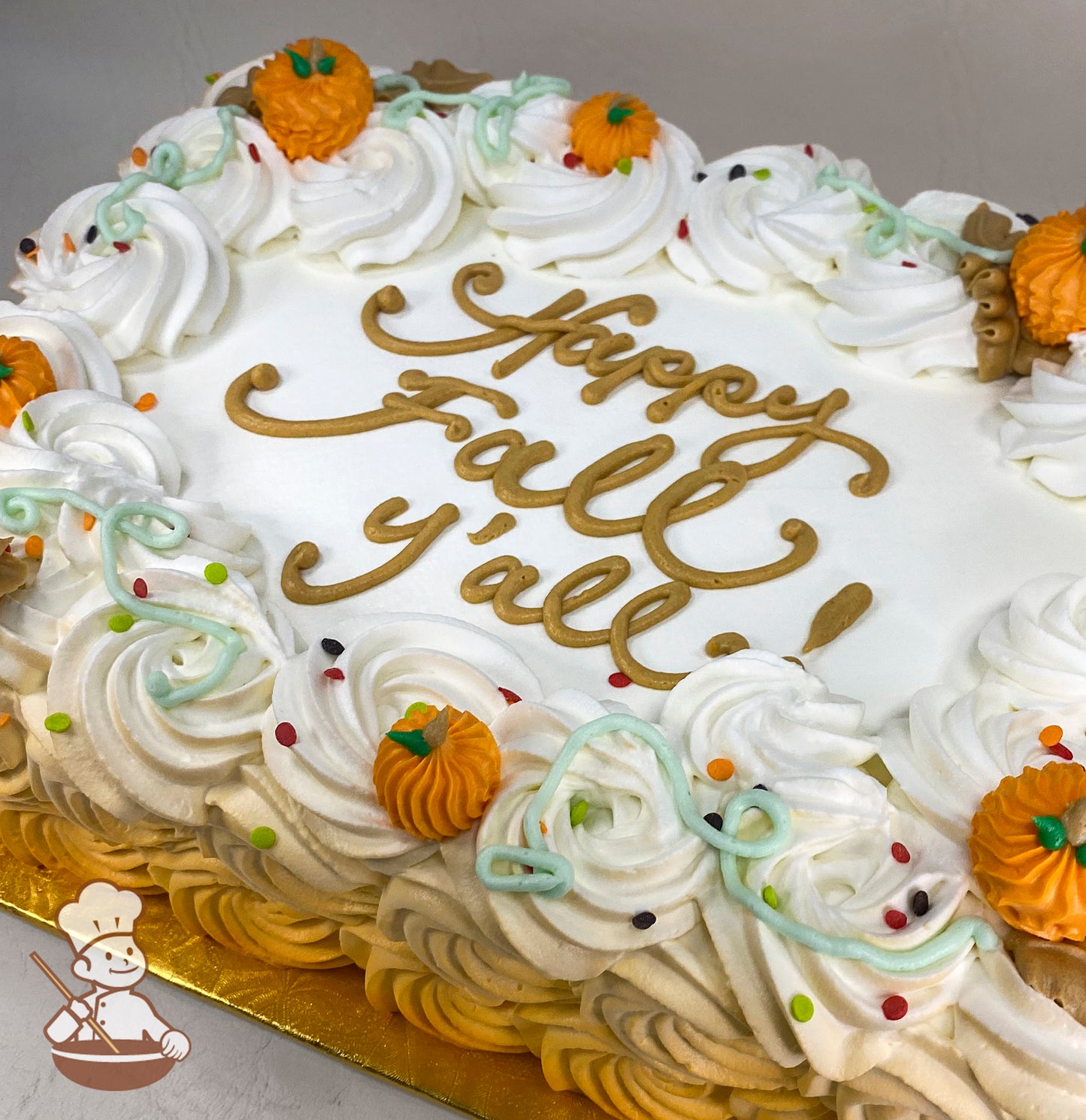 Sheet cake with buttercream rosette swirls, textured pumpkins, and vines. Decorated with colorful sprinkles and buttercream pumpkins.