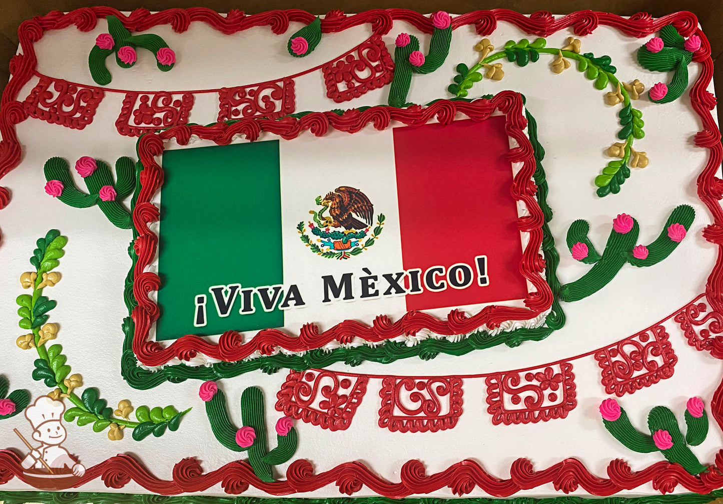 Sheet cake with red buttercream borders, green and pink cactus decorations, yellow and green vine accents, and red papel picado banner designs.