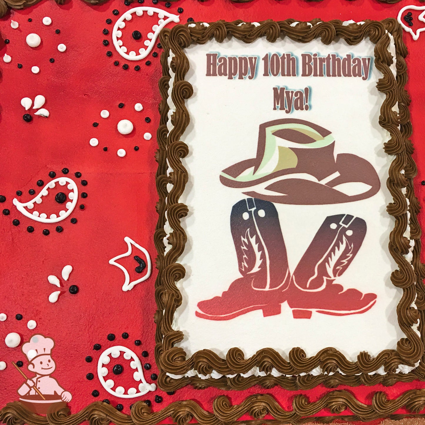 Red sheet cake with paisley designs in white and black icing. Brown buttercream border surrounds a printed image.