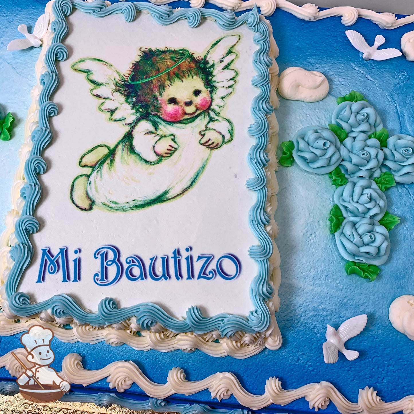 Sheet cake with blue and white buttercream borders, blue rose cross, and plastic doves.