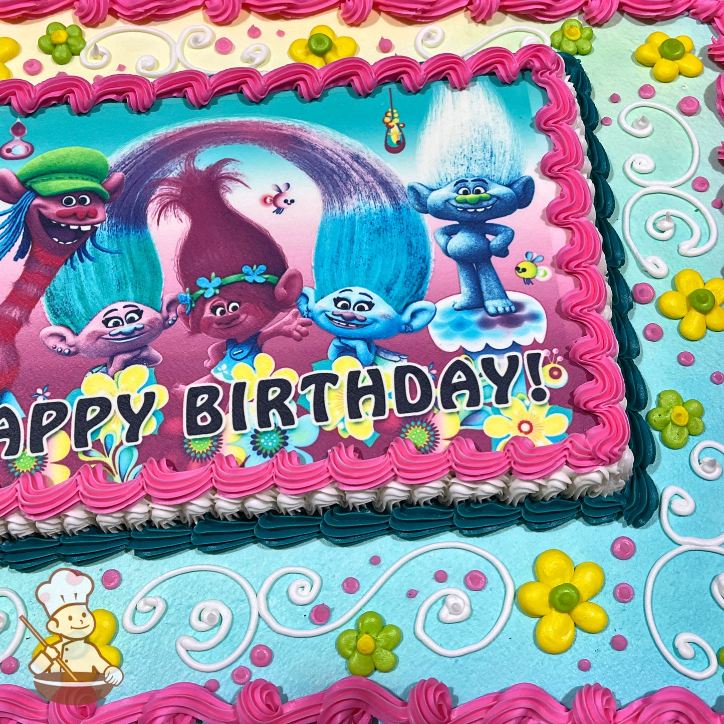 Sheet cake with pink, white, and teal buttercream borders, yellow and green daisy decorations, and white scroll designs on a blue background.