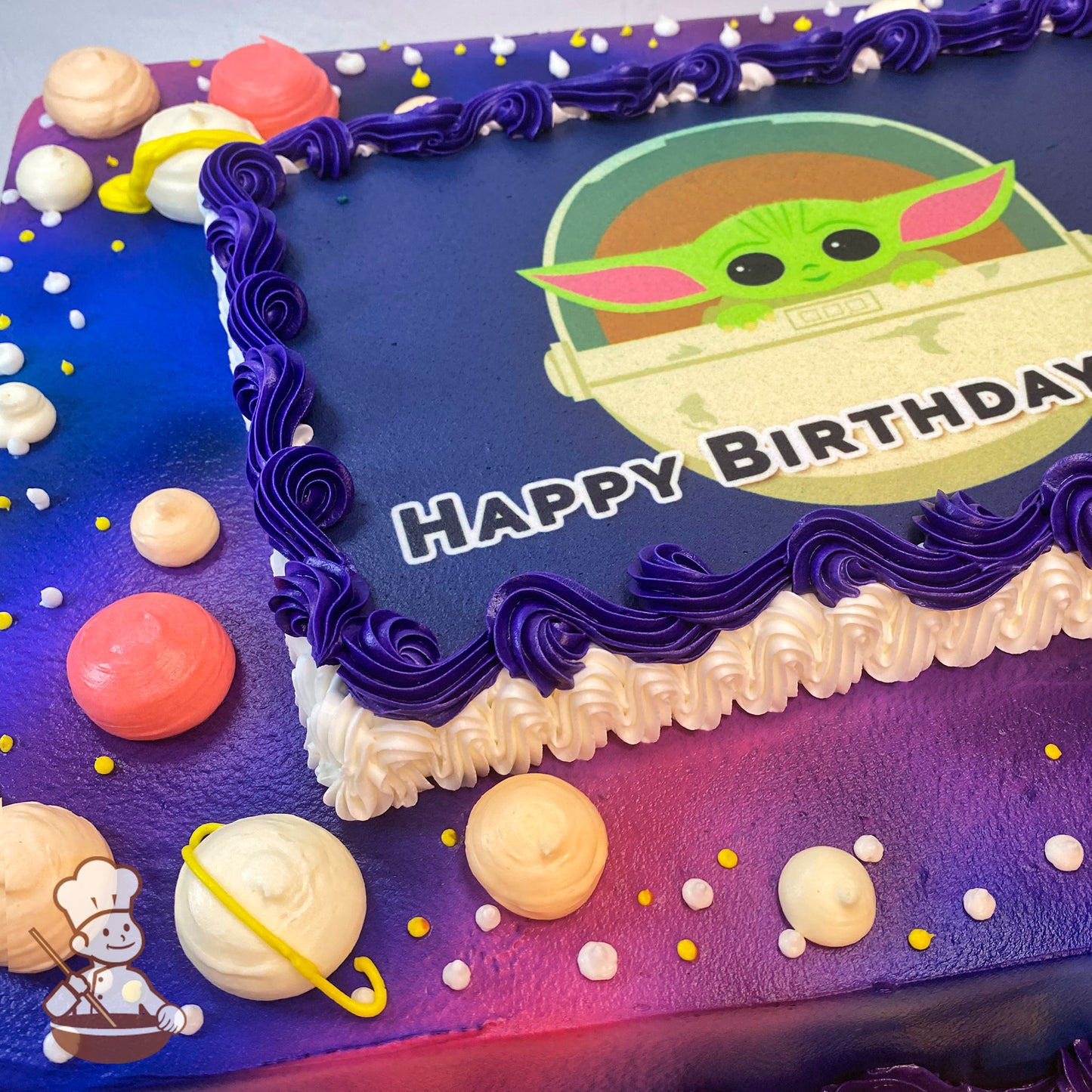 Sheet cake with a purple and pink galaxy-themed background, buttercream planets in pastel colors, yellow accents, and a purple border.
