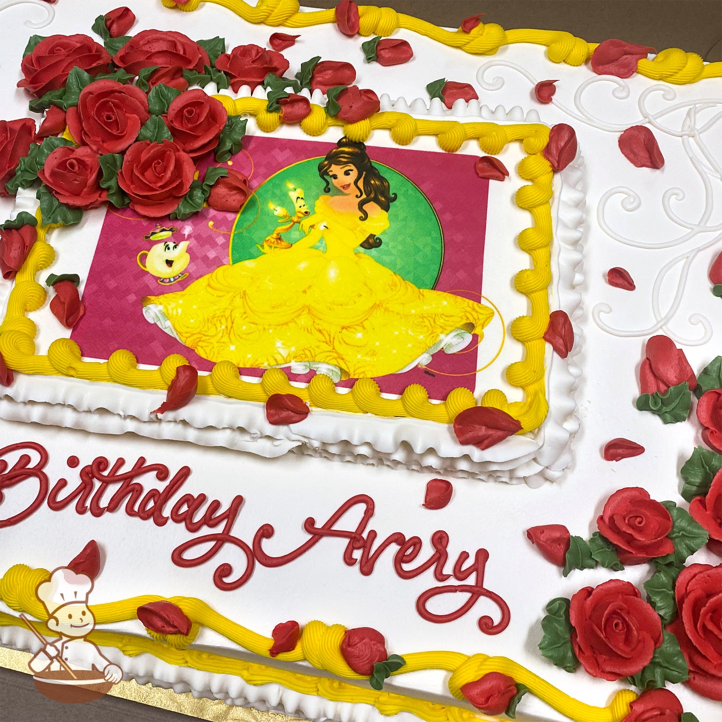Sheet cake with white frosting, red buttercream roses, scattered red rose petals, yellow frosting borders, and a printed photo layer.