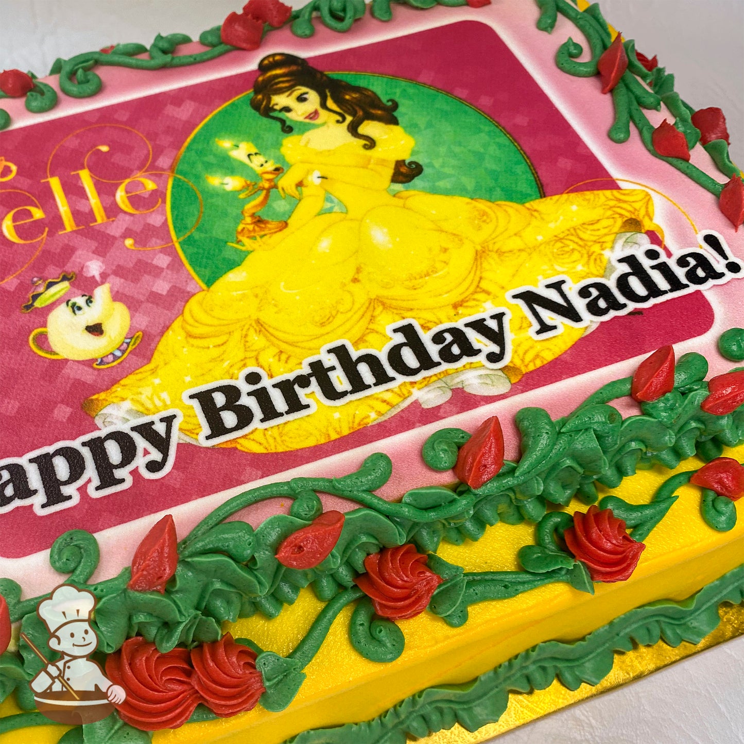 Sheet cake with a printed photo layer, bordered by green buttercream vines, red swirlette roses, and rosebud decorations.