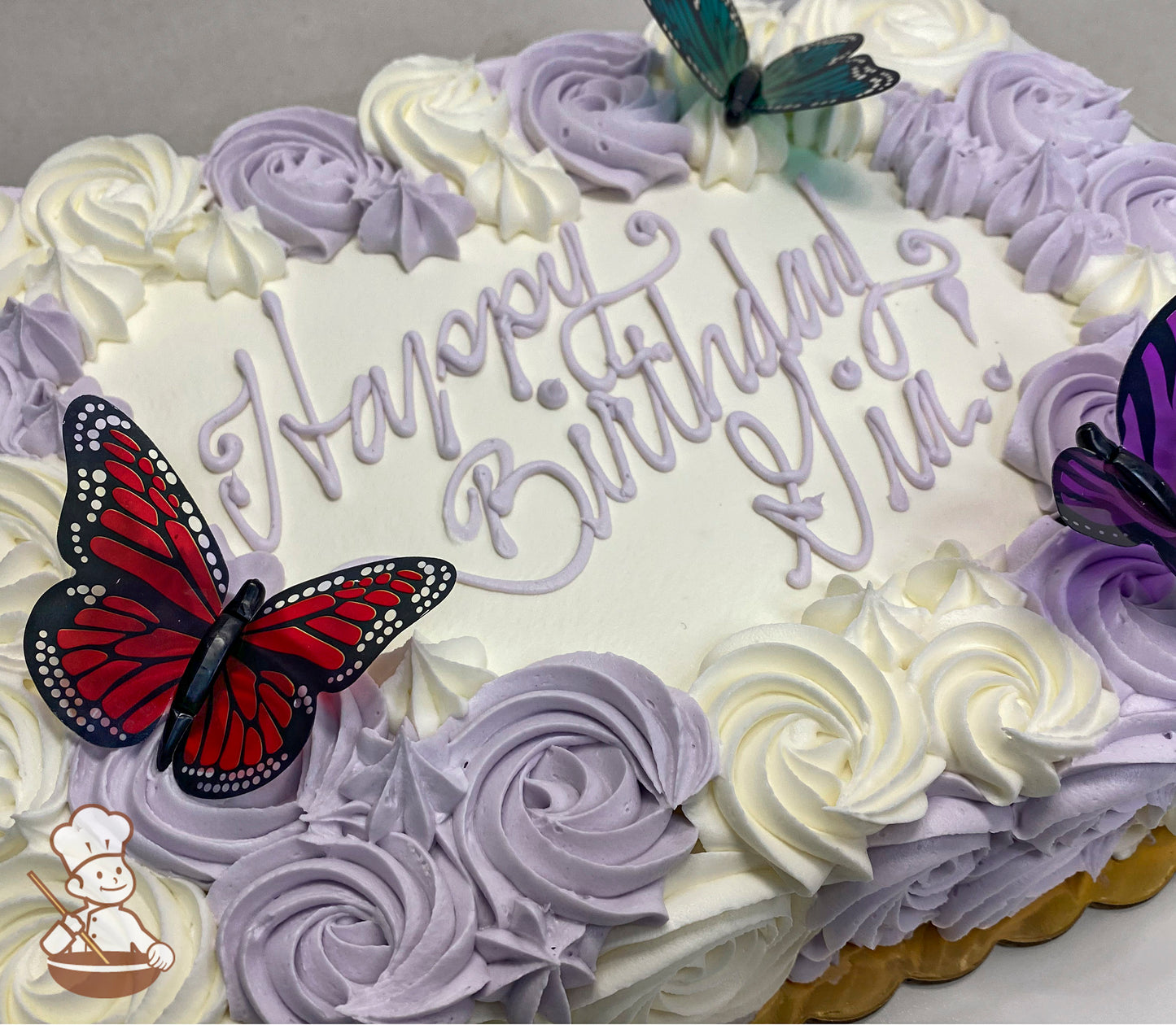 Sheet cake with white frosting, decorated with purple and white buttercream rosettes, and adorned with red, purple, and teal translucent butterfly toppers.