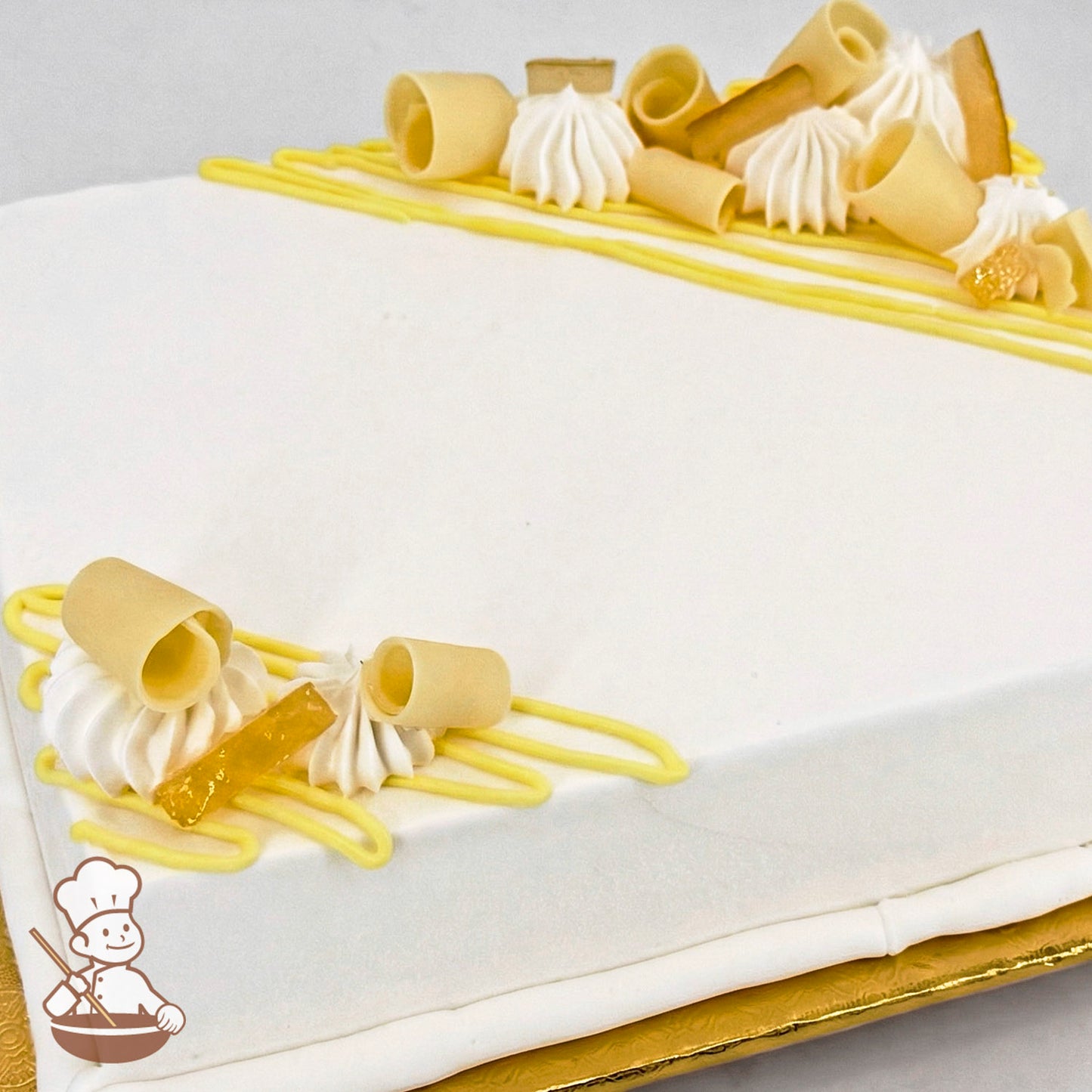 Sheet cake with white frosting, decorated with yellow buttercream lines, white chocolate curls, and candied lemon peels.