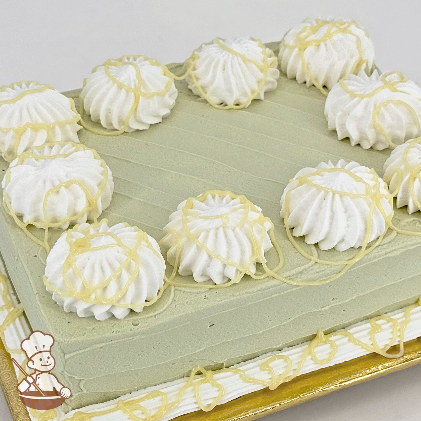 Sheet cake with green frosting, white buttercream swirls and white chocolate drizzle.
