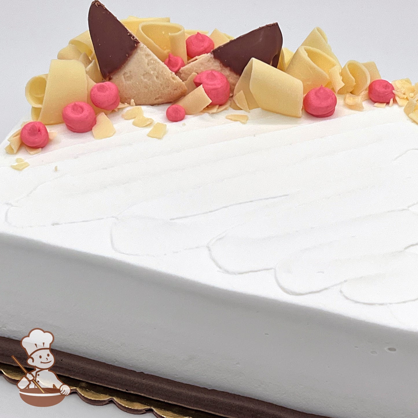 Sheet cake with white chocolate curls and chocolate dipped shortbread cookies with buttercream dollops.