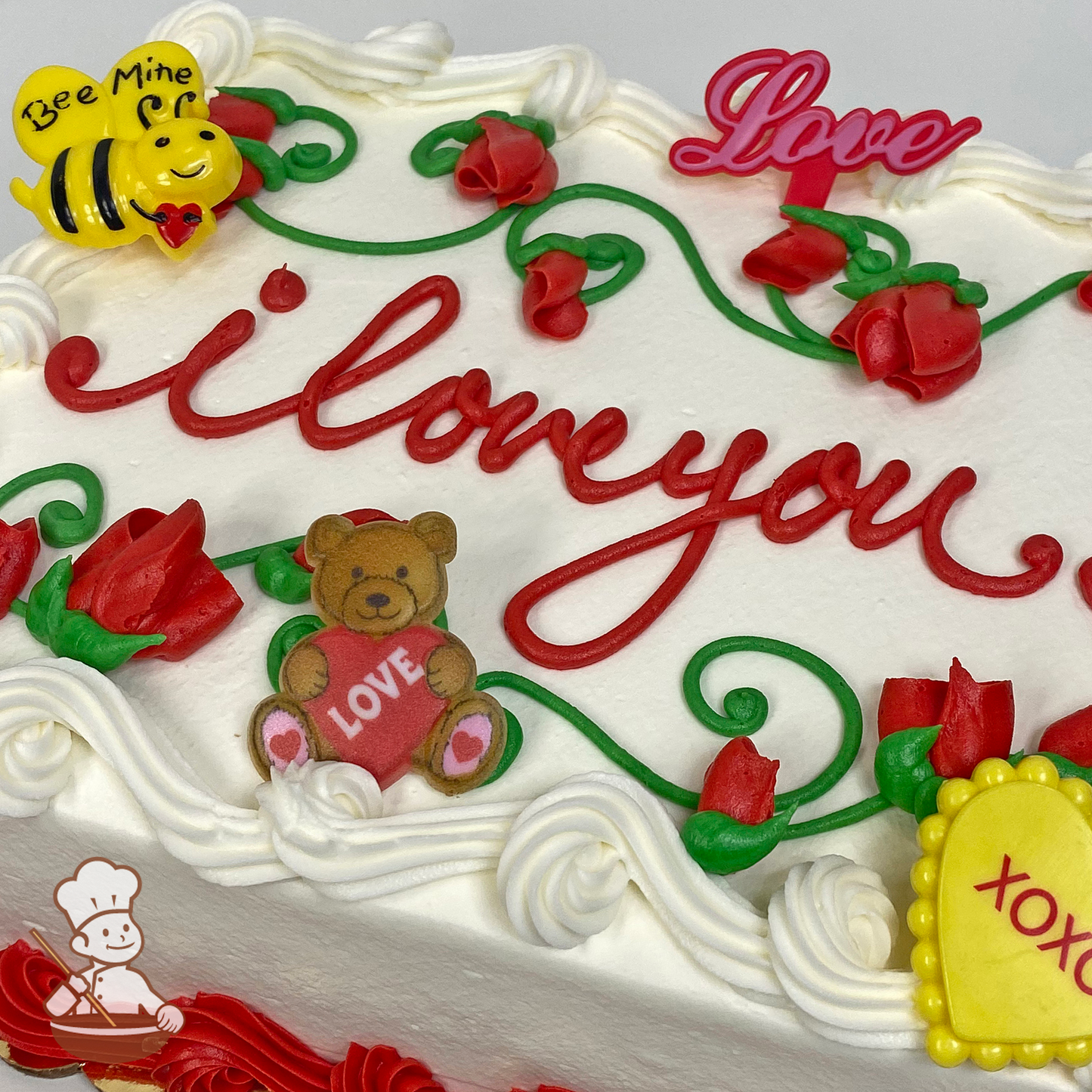 Valentine's Day sheet cake with buttercream rose buds on vines with Bee Mine bee, Love, Heart Teddy Bear and xoxo toy rings.