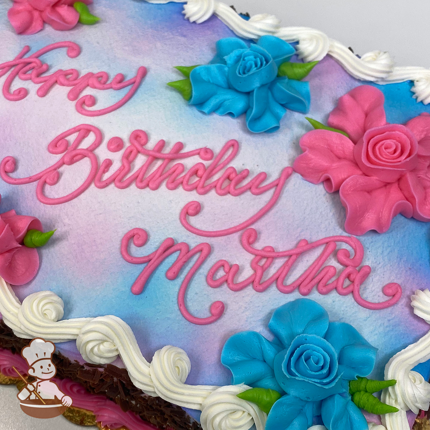 Birthday sheet cake with buttercream Hawaiian flowers and tie dye background.