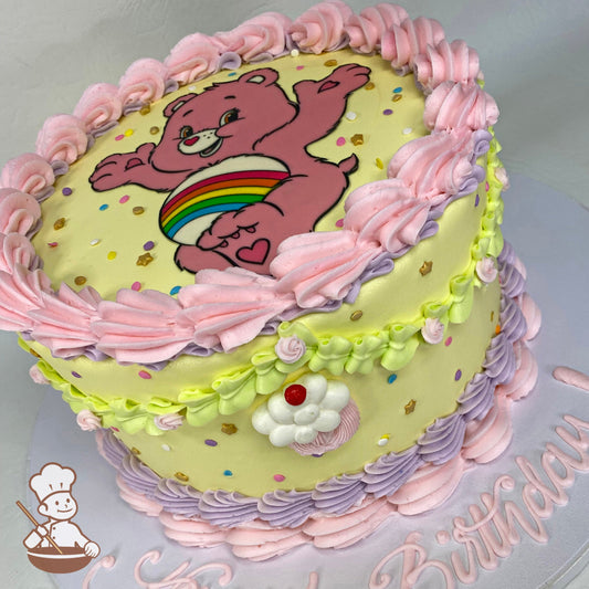 Single tier cake with yellow icing and a printed image of Cheer Bear on top of the cake and cute colorful pastel-toned buttercream piping's.