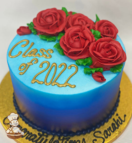 Single tier cake with Ombre-blue icing and buttercream red roses on top of the cake. The cake reads "Class of 2022" in metallic gold.