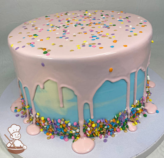 Cake with a light-blue watercolor and decorated with a pink drip and multi-color sprinkles on the base of the cake and sprinkled on top.