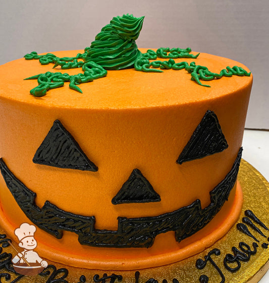 Single tier cake with smooth orange icing and decorated with black buttercream to make a cute smiling Jack-o'-lantern face.