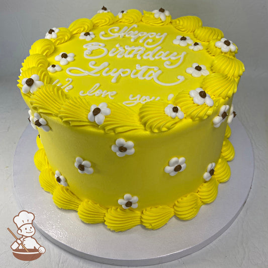 Round cake with yellow icing, yellow shell trims on top and bottom of cake and buttercream white daisies with brown center placed all over cake.