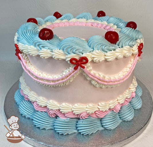 Round cake with vintage style piping's in light blue, light pink and white colors. The cake is finished off with cherries on top.
