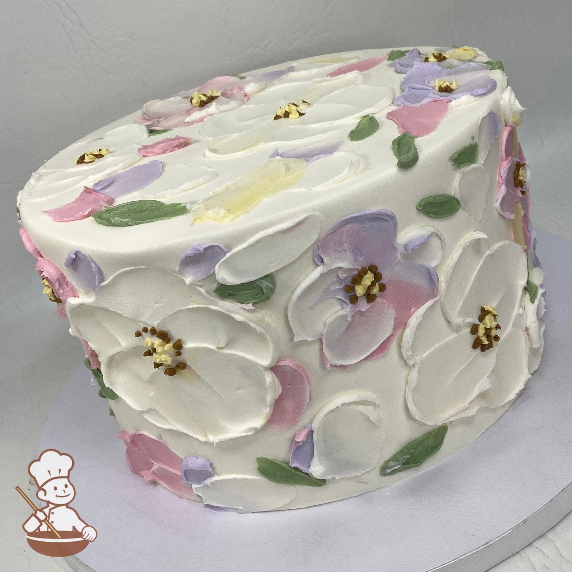 Single tier cake with smooth white icing, decorated with lavender, mauve and white palette knife flowers.