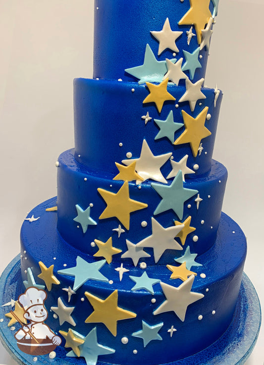 4-tier cake with white smooth icing which has been airbrushed a blue color and has light blue, white and yellow stars cascading on the tiers.