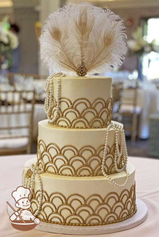3-tier cake with ivory-colored smooth icing, decorated with metallic gold half loop piping's, white pearls and a feather topper.