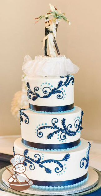 3-tier cake with smooth white icing and decorated with navy blue buttercream scrolls and a navy blue satin ribbon.