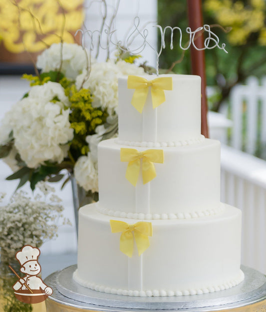 Smooth white buttercream icing with yellow satin ribbon bows