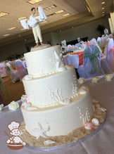 3-tier white cake with kelp bubbles and seashells. Bottom base is decorated with brown sugar sand.