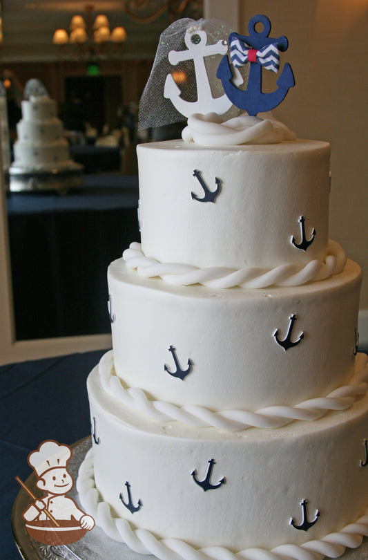 3-tier cake with blue anchor decorations on cake wall. Cake trim is made with fondant rope.