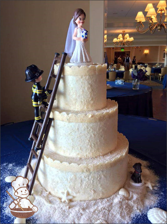 3-tier cake with patted sugar sand and top of each tier with added castel trim.