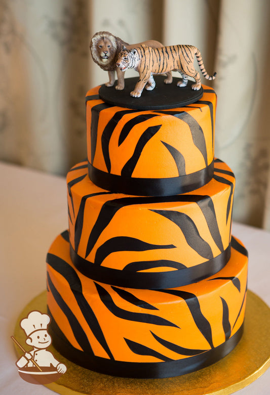 3-tier orange cake with black tiger stripes and satin black ribbon.