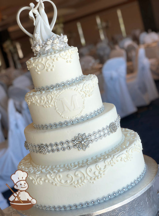 4-tier cake with white smooth icing and decorated with white buttercream scrolls, diamond bands and a custom fondant monogram.