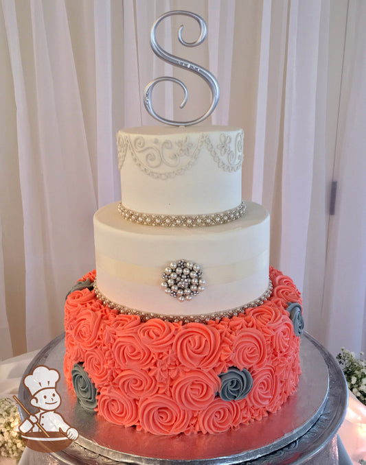 3 tier round wedding cake with coral and gray rosette swirls wrapped with pearl bead band & finished with monogram topper and pearl broach.