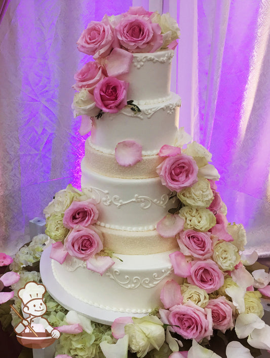 Multi tiered round cakes with cream sugar crystal covers and buttercream piping.  Cake is finished with cascading fresh flowers.