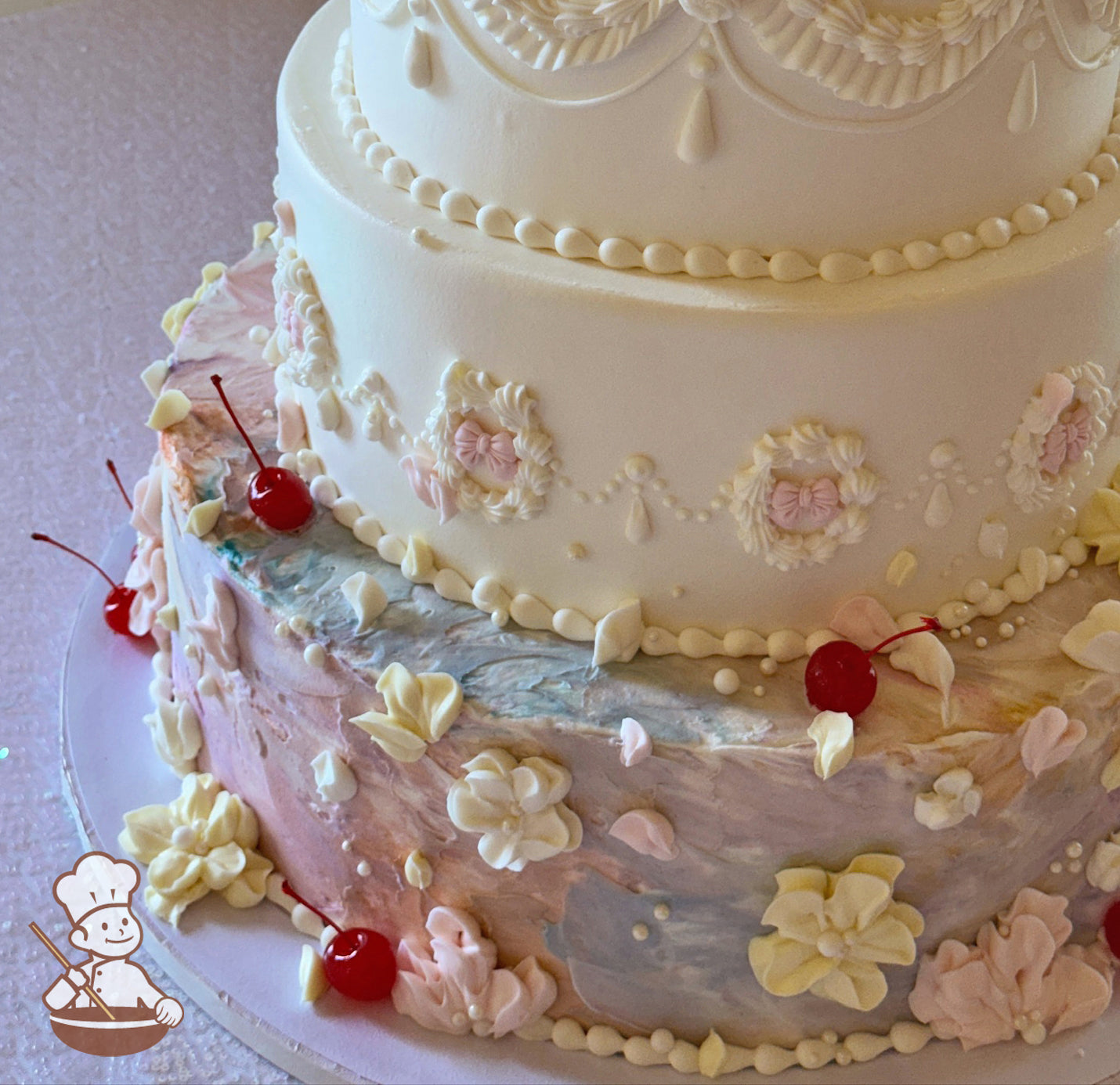 Pastel rainbow texture cake with buttercream flowers and maraschino cherry. Fondant bows in middle of vintage piping design.