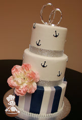 3 tier fondant wedding cake with vertical white, navy blue and gray fondant stripes and decorated with navy blue anchors on top 2 tiers.
