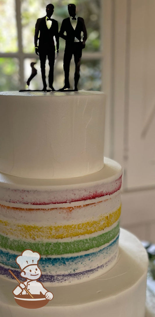 3-tier cake with middle tier baked with layers of cake in color of the rainbow and iced with sheer white buttercream. Top and bottom tiers white.