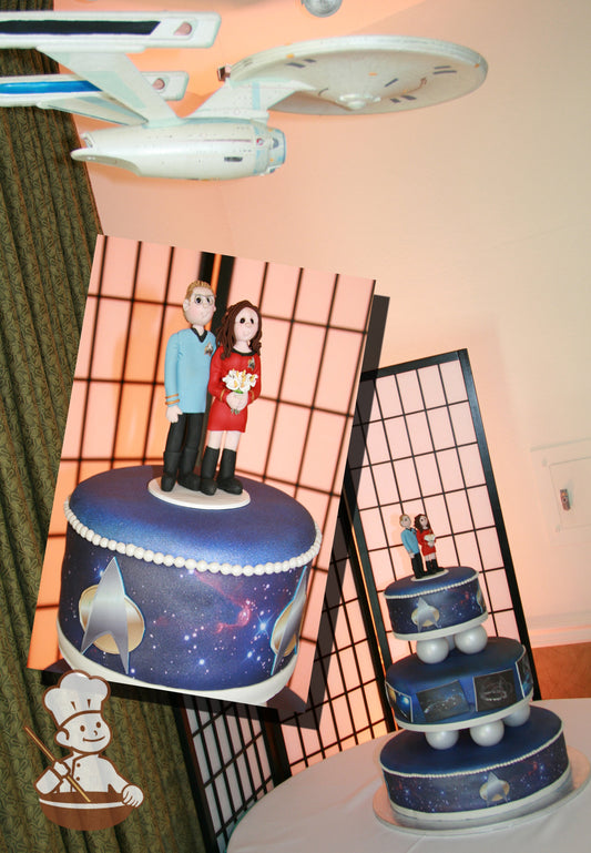 Blue 3-tier cake separated by iridescent white balls as pillars. Cake tiers have photo images of Star Trek themes.