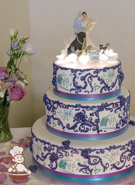 3-tier cake with blue and purple ribbons. Decorated with purple grape cluster scrolls and printed music themes.