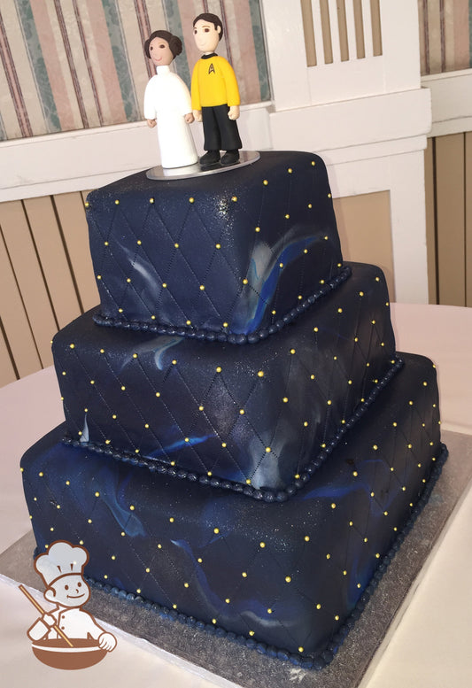3-tier square cake with fondant quilt pattern and gold dots. Cake is blue with streaks that look like the galaxy.