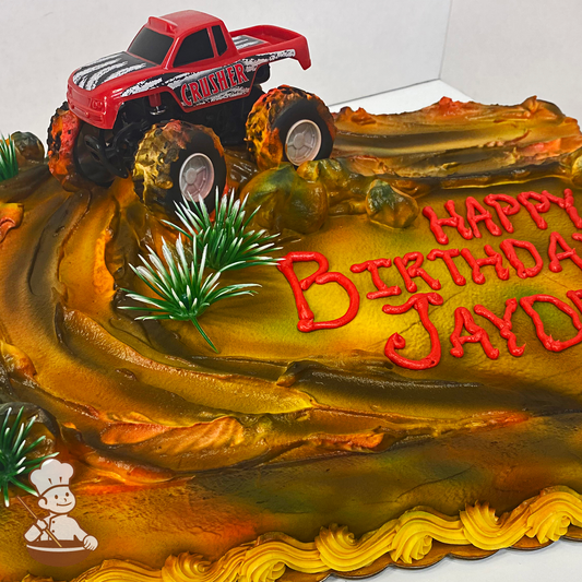 Birthday sheet cake with buttercream dirt mounds and monster truck toy.