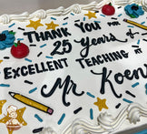 Sheet cake with white buttercream frosting, decorated with red apple designs, blue flowers, yellow stars, a yellow pencil, and blue and black sprinkles.