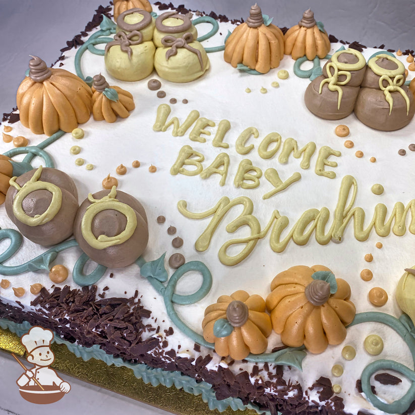 Sheet cake with buttercream decorations featuring baby booties, orange pumpkins, green vines, and small buttercream dots.