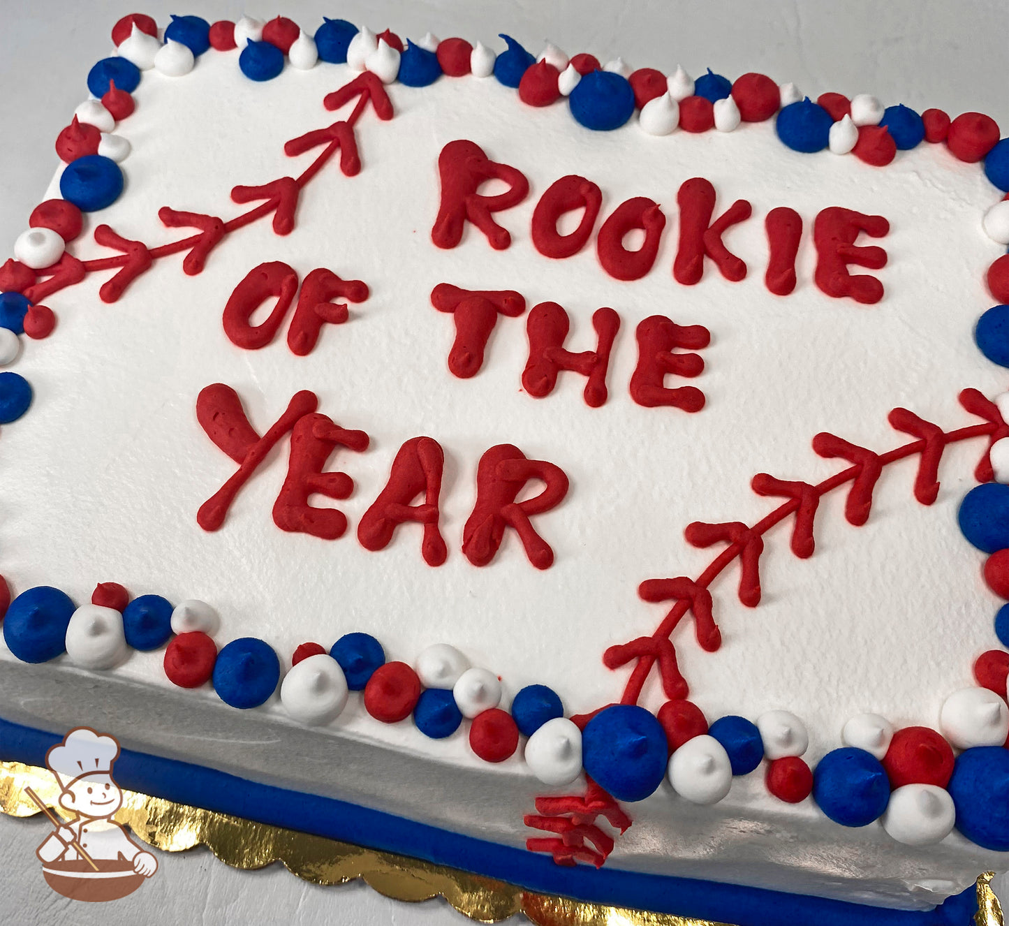 Sheet cake with red buttercream baseball stitches, bordered by red, white, and blue buttercream dots.