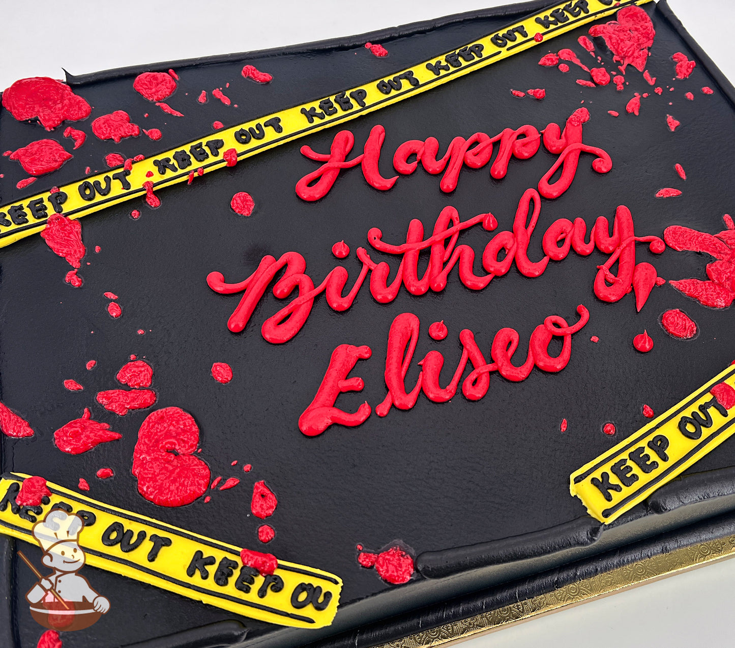 Black sheet cake with red buttercream blood splatters and yellow caution tape decorations reading "Keep Out."
