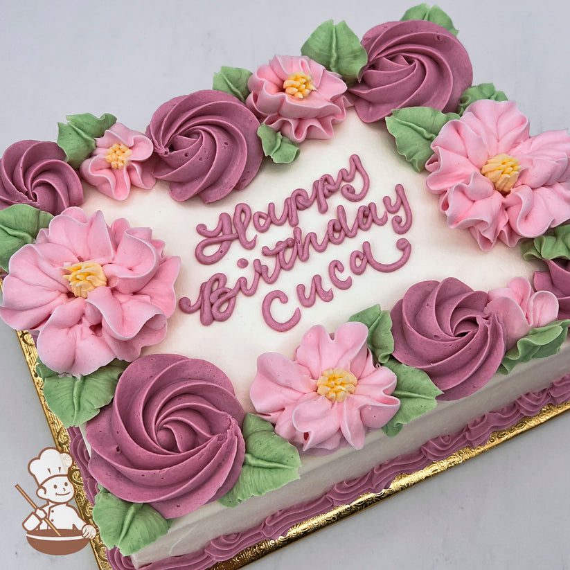 Sheet cake with pink buttercream flowers, including blossoms and swirled rosettes, accented by green leaves on a white frosting base.