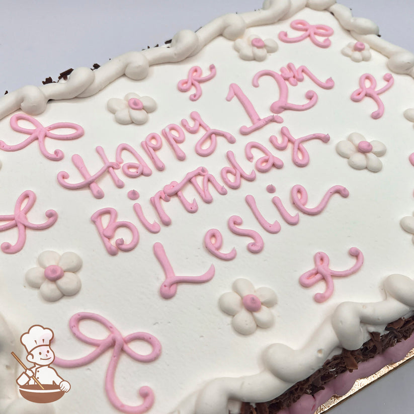 White sheet cake with pink buttercream bows, white buttercream daisies with pink centers, and a piped white border.